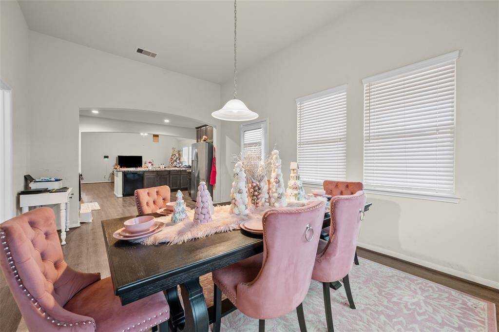 A close-up view of the dining room area showcasing the kitchen area in the background