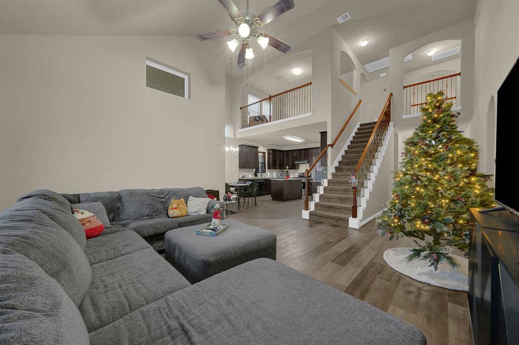 Spacious living area with beautiful view of stairs and located just off the kitchen, perfect for entertaining.