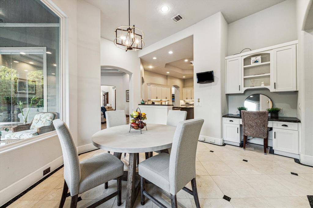 The breakfast area, bathed in natural light, provides a warm and inviting space for casual meals, while the small office features a cozy, efficient layout with built-in shelves and a compact desk, creating the perfect environment for focused work.