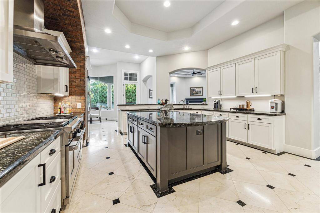 The kitchen is open and spacious, featuring ample cabinetry for storage and a beautifully convenient island table at the center, perfect for meal preparation and casual dining.
