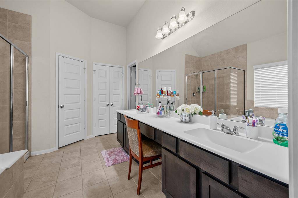 Master bathroom featuring a cozy seating area.