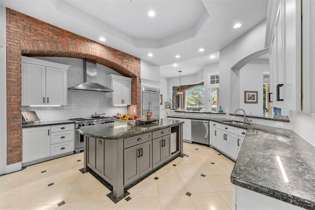 The kitchen boasts top-of-the-line Thermador refrigerator and Wolf oven, seamlessly blending style and high performance for the ultimate culinary experience.