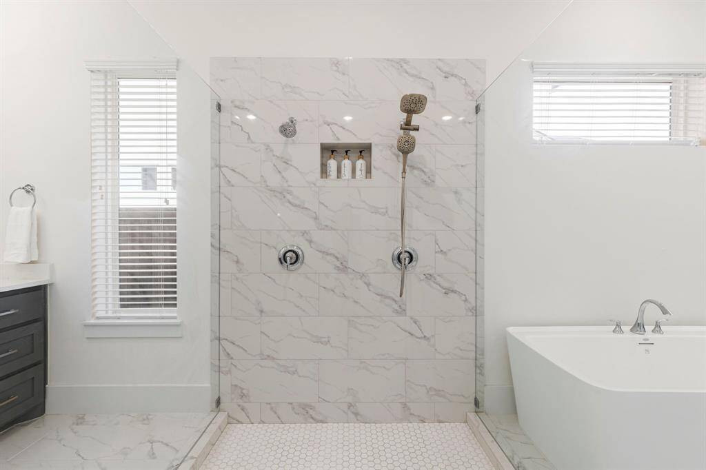 Expansive seamless shower with dual shower heads.