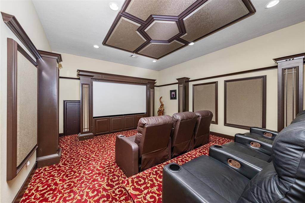 The home features a private theater room, perfect for hosting movie nights, complete with plush red carpeting and soundproof walls for an immersive viewing experience.