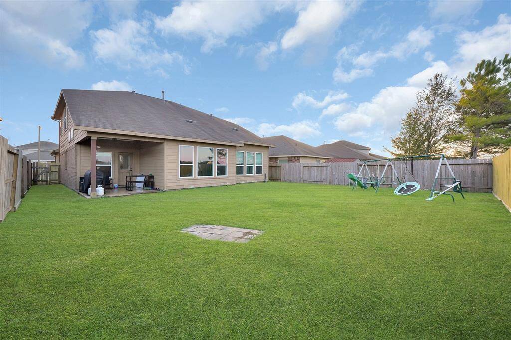 Second, angled view of the back of the home and large backyard.