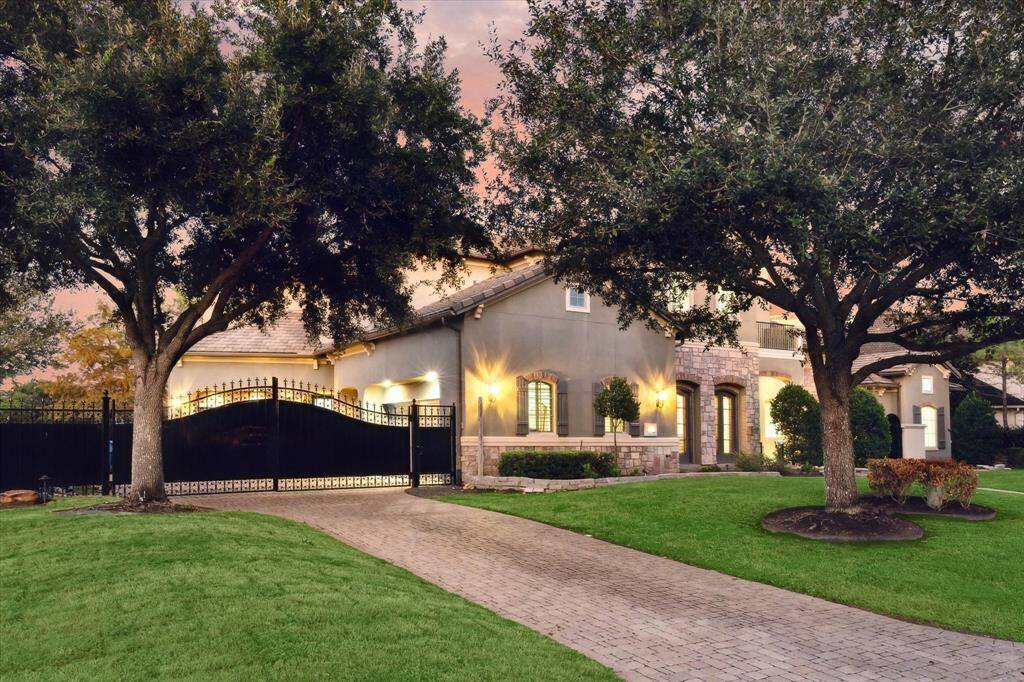 A grand gated driveway welcomes you to an elegant residence featuring a spacious three-car garage, capable of accommodating up to 12 vehicles, and private iron gate to ensure privacy and security.