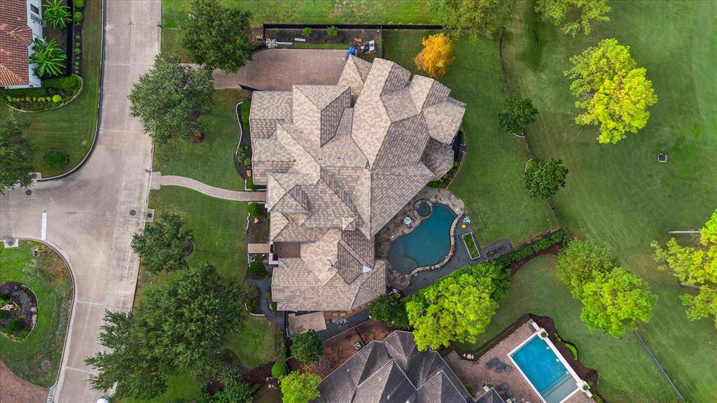 The aerial view of the home captures its stunning architecture and beautifully landscaped grounds, providing a comprehensive perspective of the property and its surroundings. Updated roof from 2021, recently cleaned in 2022.