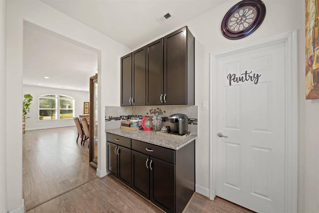 The butler’s pantry with granite countertops, ample cabinet storage, and easy access to the dining area for seamless entertaining. The large pantry has built-in shelves for easy organization. Panty estimated size 6'3"X8'7"