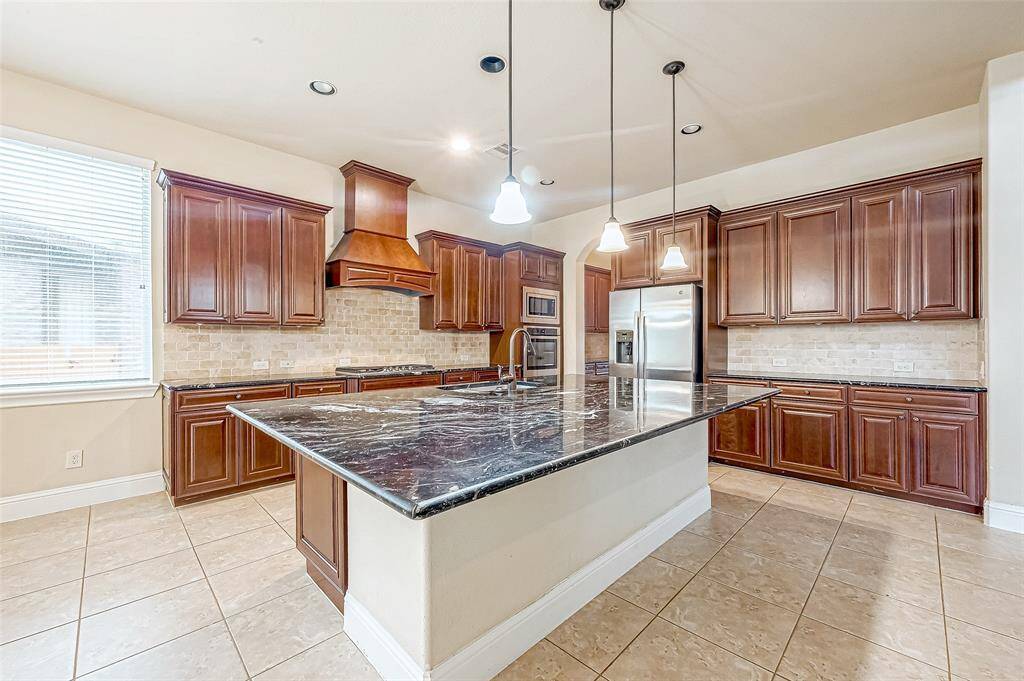 Stunning kitchen with rich wood tones, sleek countertops, and modern appliances.