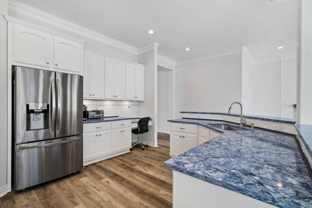Open Kitchen with many cabinets and desk area at the end of the counter.