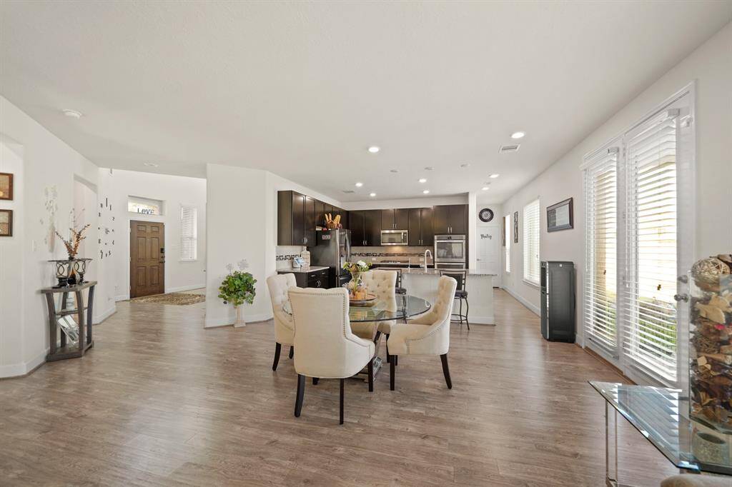 The spacious, open breakfast area with wood-style flooring and easy access to the modern kitchen creates a perfect space for meals and gatherings.