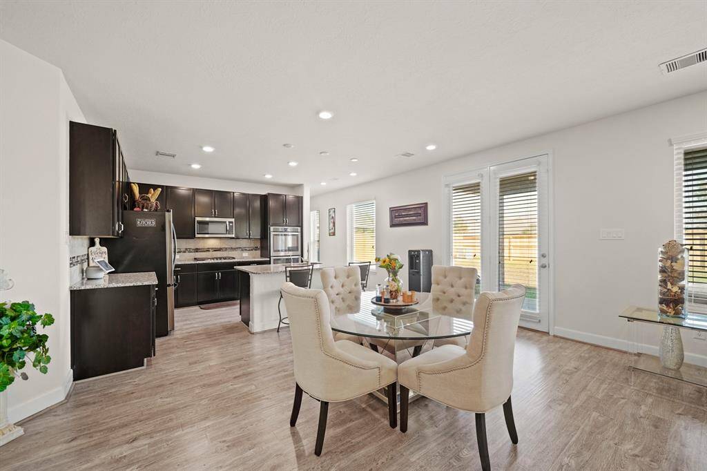The spacious, open breakfast area with wood-style flooring offers plenty of natural sunlight to enjoy morning coffee or tea.