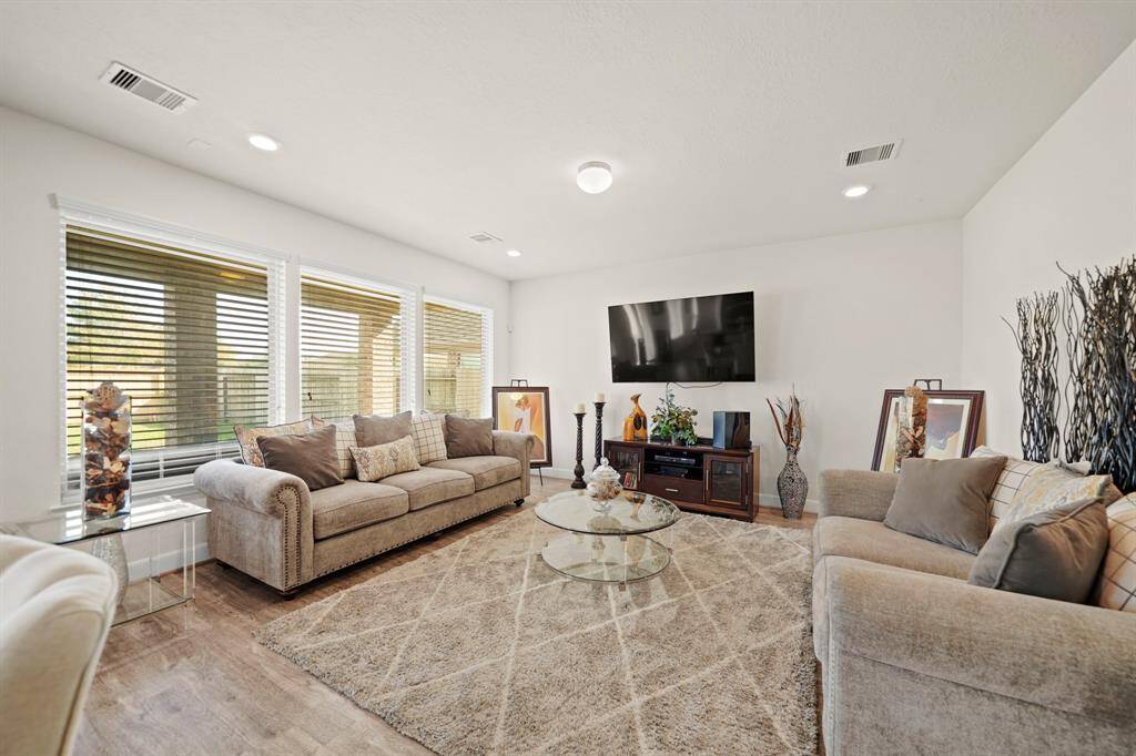 The spacious living room, with abundant natural light and large windows, is perfect for relaxing or entertaining.
