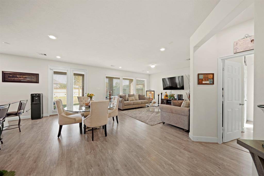 This open-concept design features a breakfast area, spacious living room, and large windows offering ample natural light, perfect for modern living and entertaining.