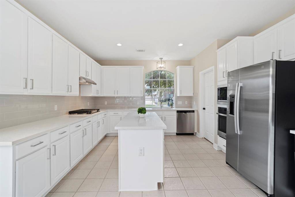 The kitchen has new features including Quartz countertops, new sink and faucet, new backsplash, light fixtures, and can lights.