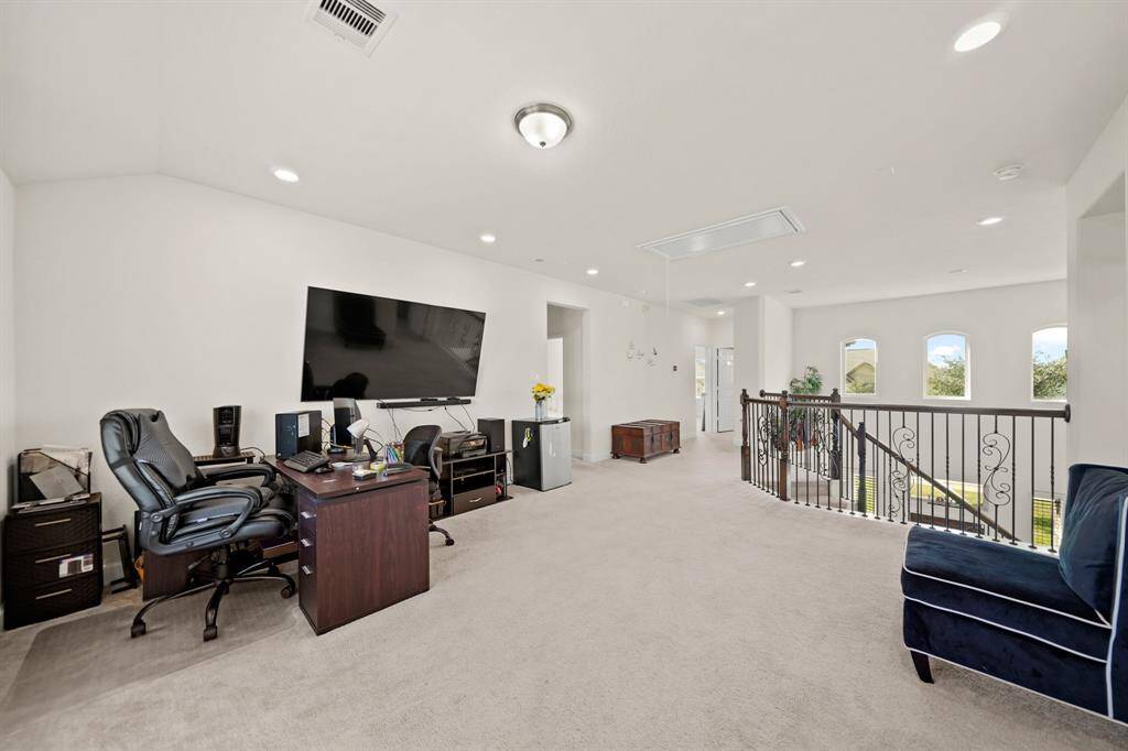 Spacious upstairs game room with plush carpeting and plenty of space for relaxation or work, offering versatility for entertainment or productivity.