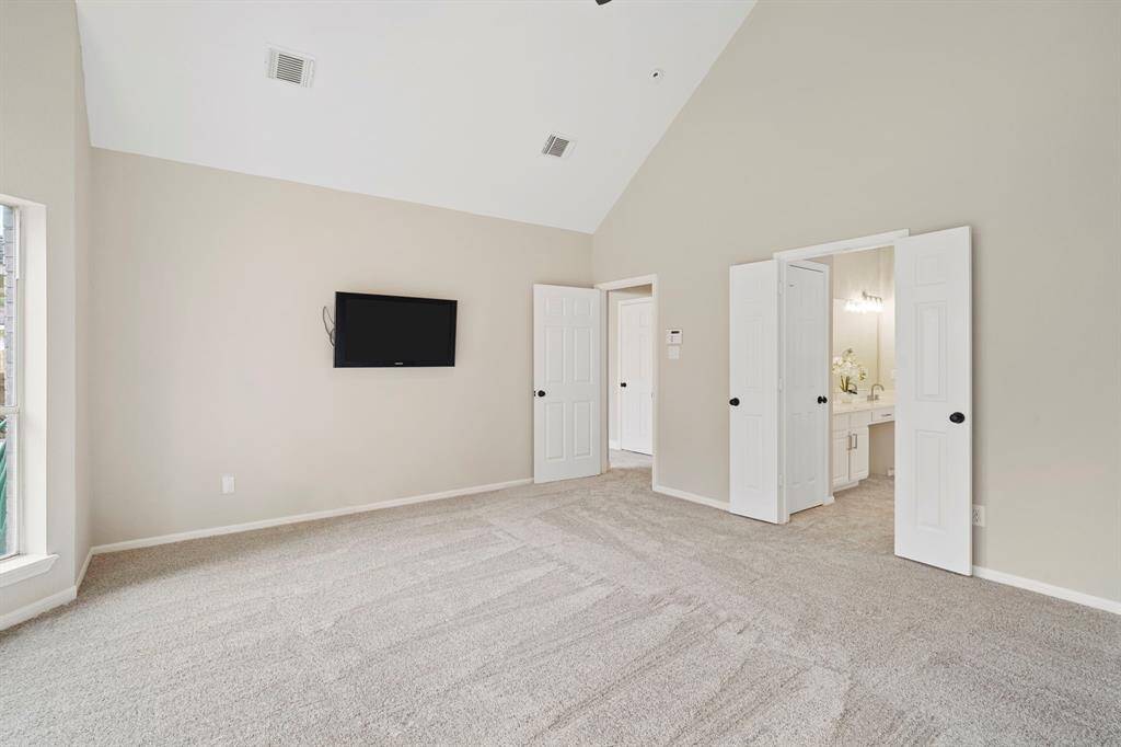 The primary bedroom features high ceilings and an en-suite bathroom.