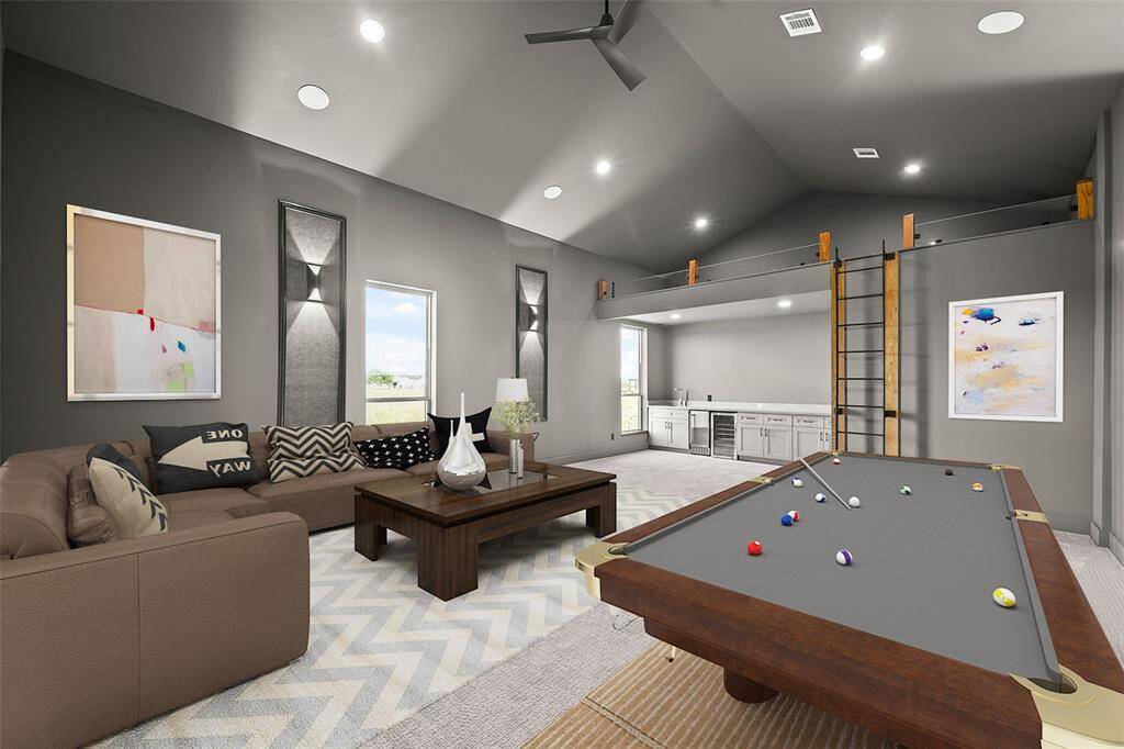 Large game/media room features plenty of room for a comfortable seating area, game table, and a lofted space. The room is well-lit with recessed lighting and includes a mini-fridge, ice maker, and sink. Perfect for gatherings. (virtually staged setting)