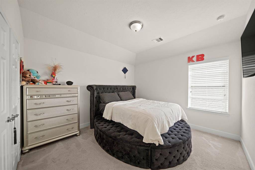 Charming second bedroom upstairs with plush carpeting and ample natural light for a cozy and inviting space.