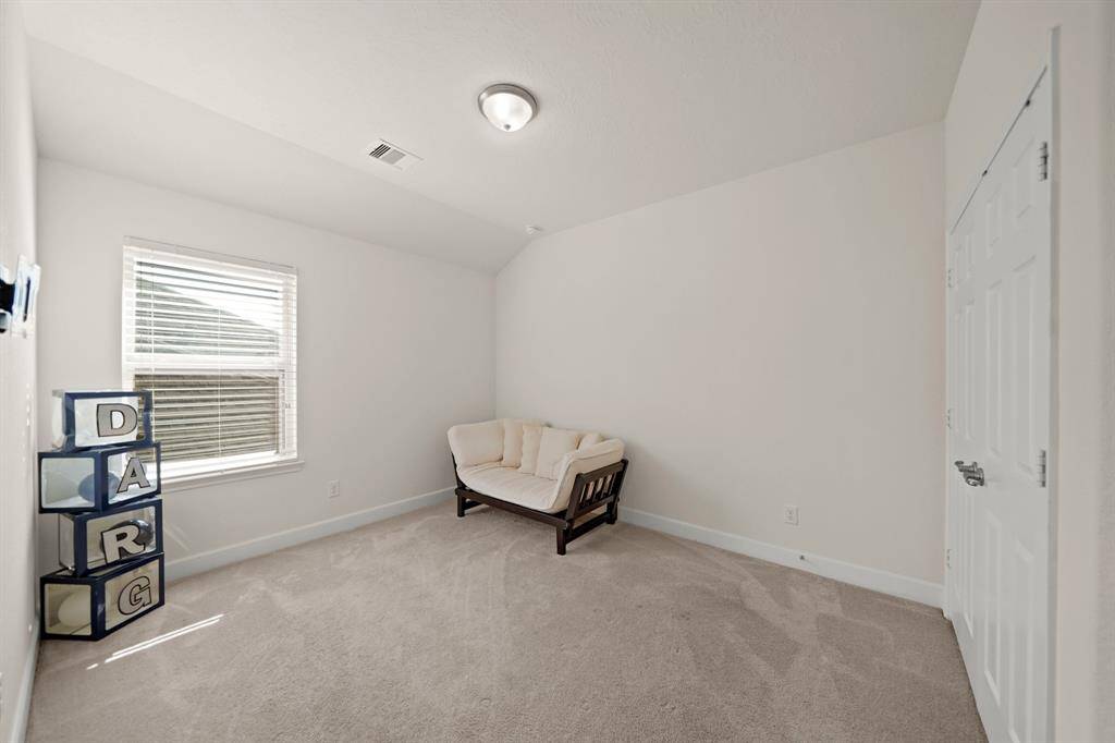 3rd bedroom upstairs with plush carpeting, natural light, and ample space for customization.