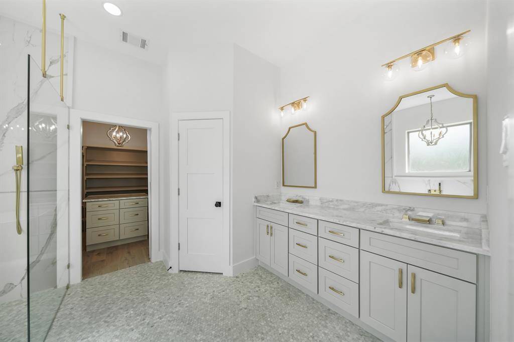 Bright bathroom with a double vanity and elegant gold fixtures.