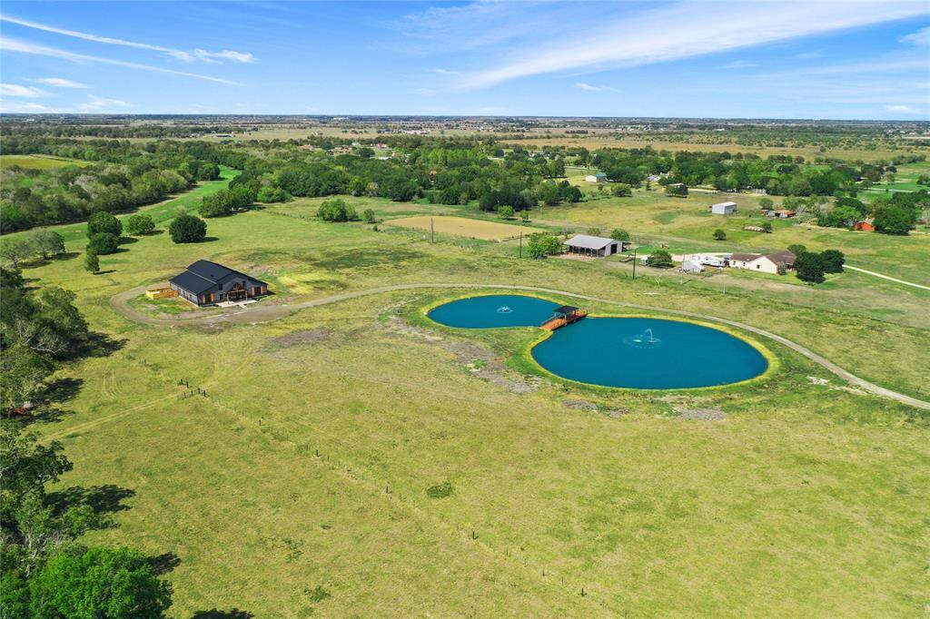 This aerial photo showcases a spacious rural property and scenic views.
