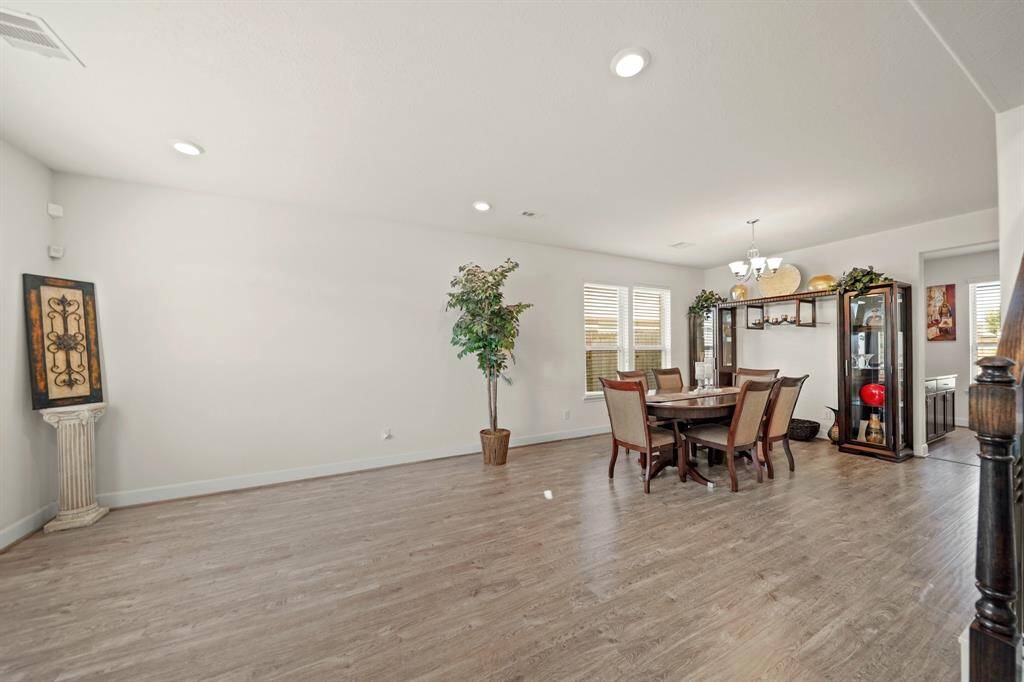 The spacious formal living and the formal dining area have natural light, wood-styled flooring, and an open layout perfect for gatherings and entertaining.
