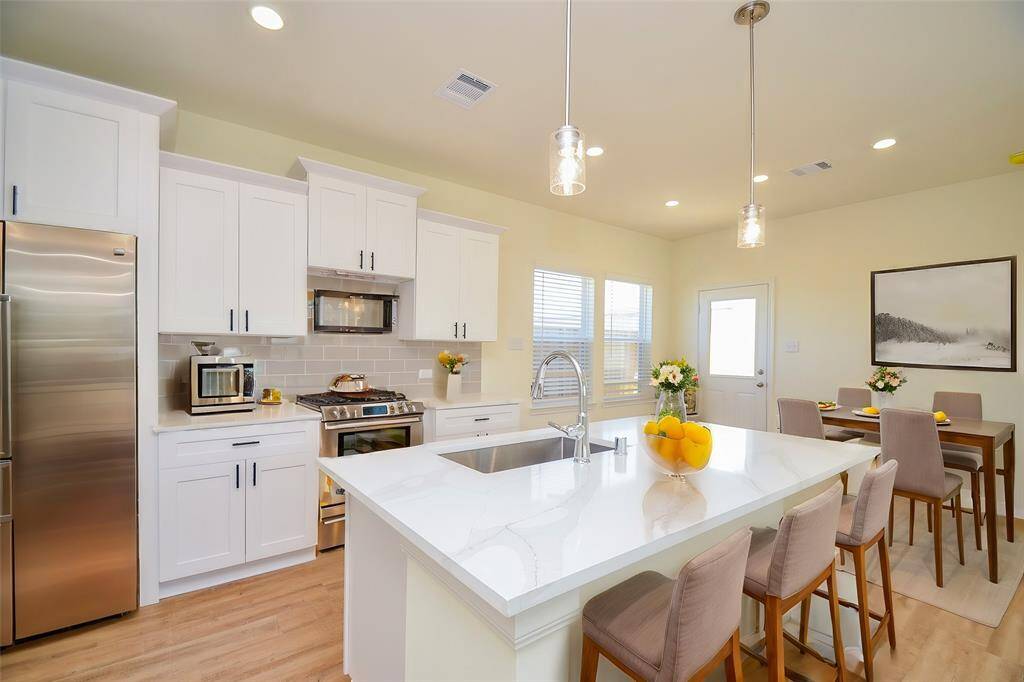 The sleek white cabinetry offers ample storage and a bright and airy feel.