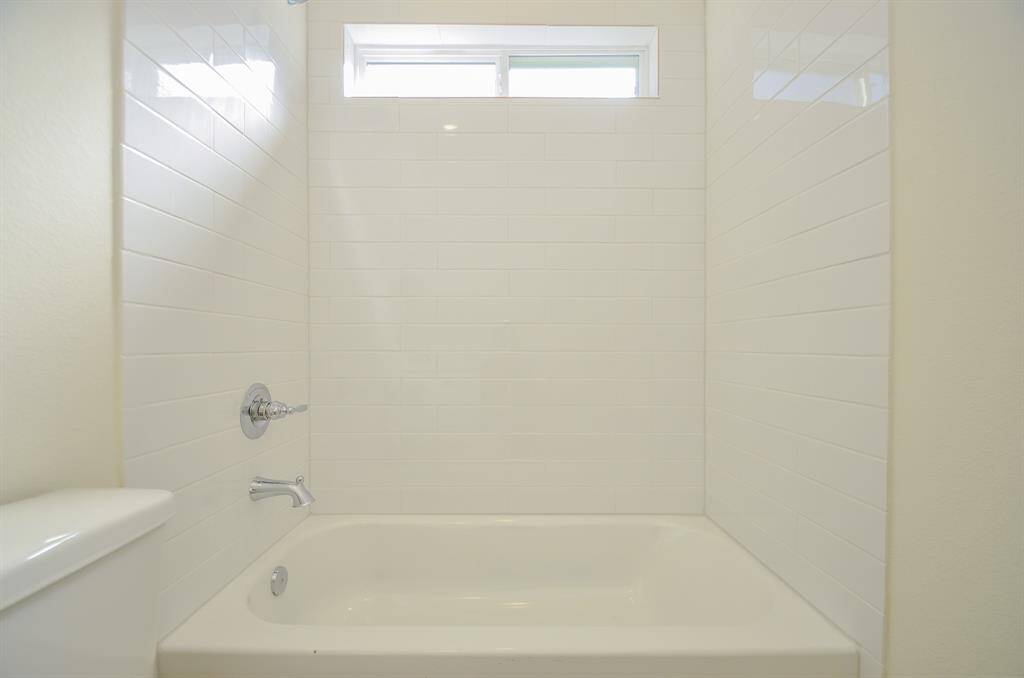 The white tile and fixtures provide a fresh and inviting feel.