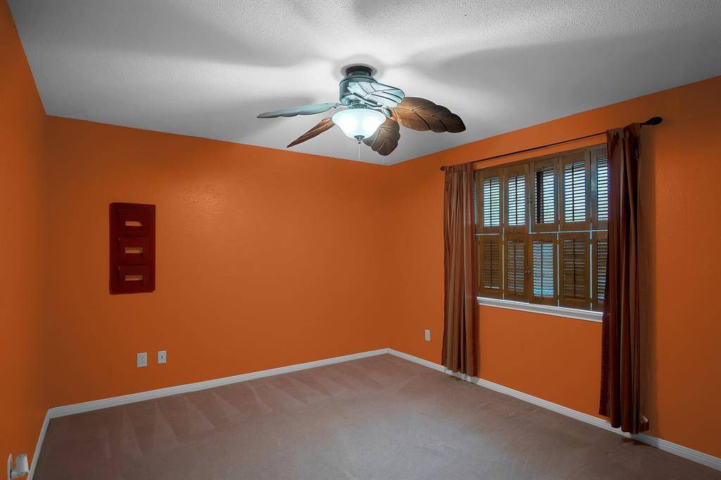 Bedroom #3 upstairs is spacious and inviting, featuring plush neutral carpet and a walk-in closet for ample storage. A ceiling fan with light fixture ensures comfort, while large windows flood the room with natural light, creating a bright and airy atmosphere.