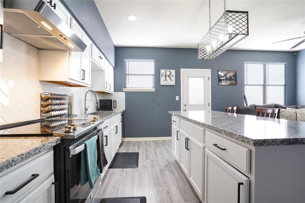 Unit B - White kitchen counters, with modern black cabinets handles, granite counters with white tile herringbone pattern backsplash!