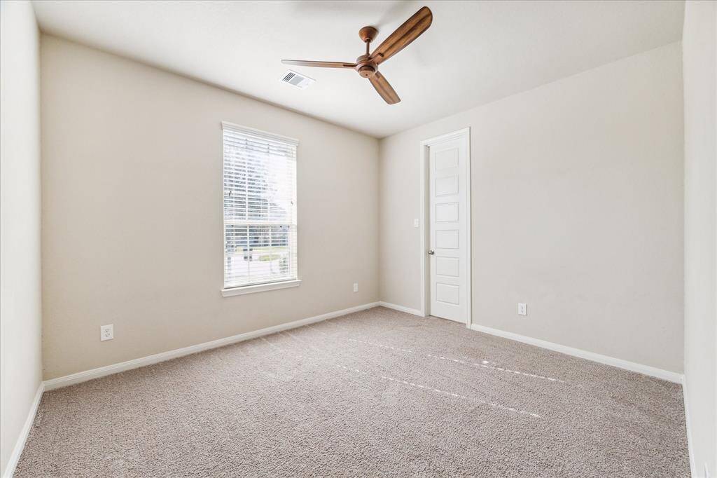 Front-facing downstairs bedroom featuring a spacious walk-in closet.