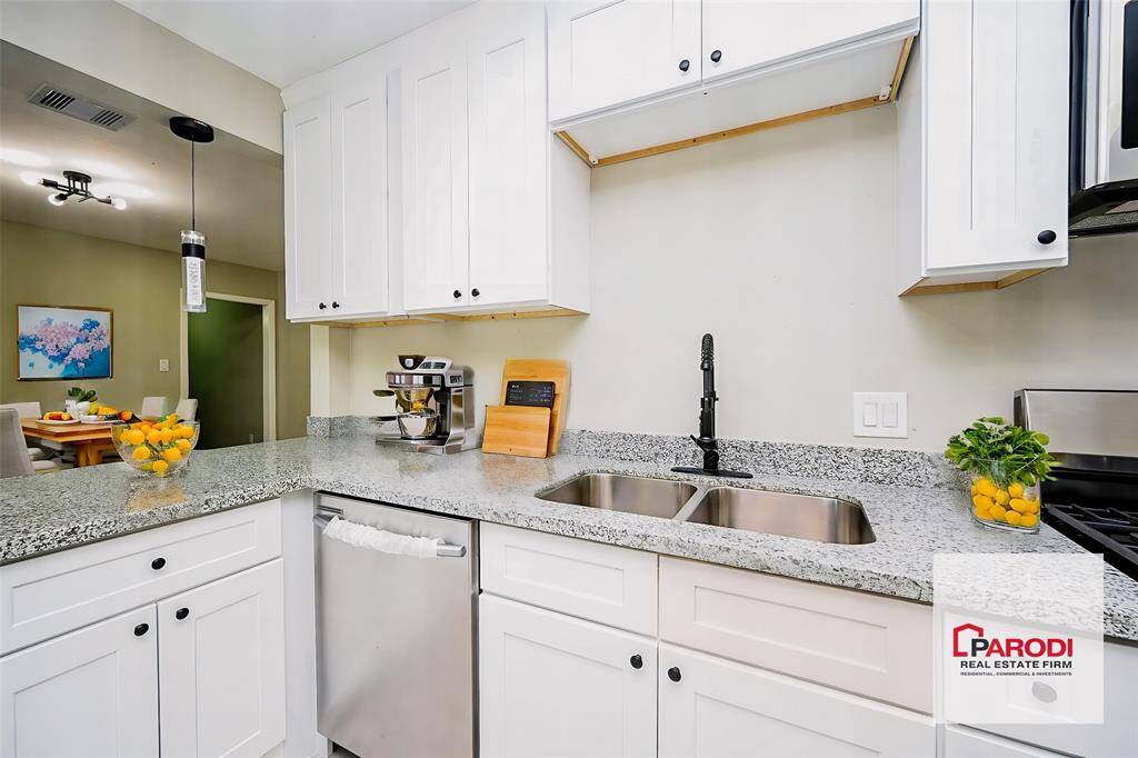 There's plenty of storage space here, and the sleek white cabinetry gives off a bright, modern vibe!