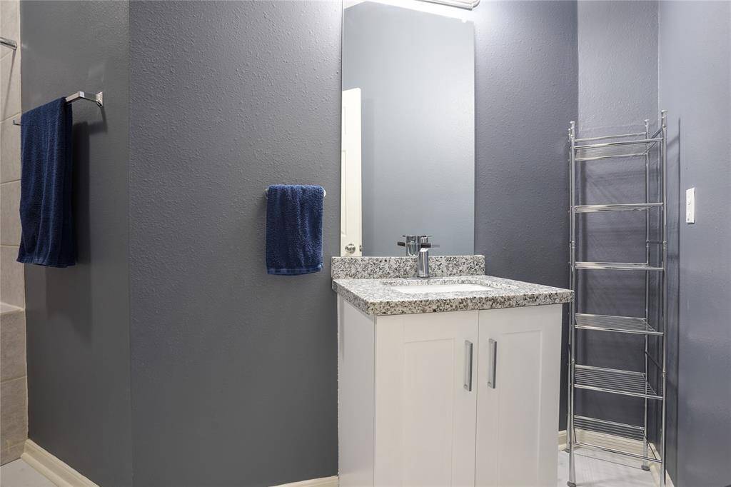 Unit B - Downstairs restroom, granite counters, and tile flooring.