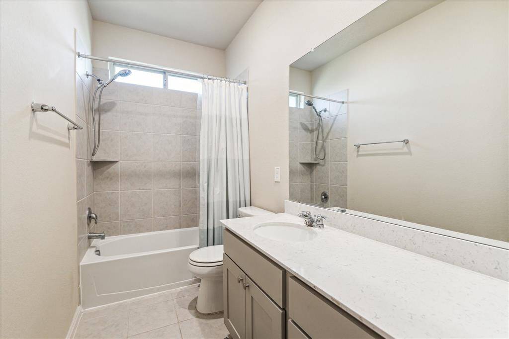 Spacious bathroom with a large vanity and a tub/shower combo.