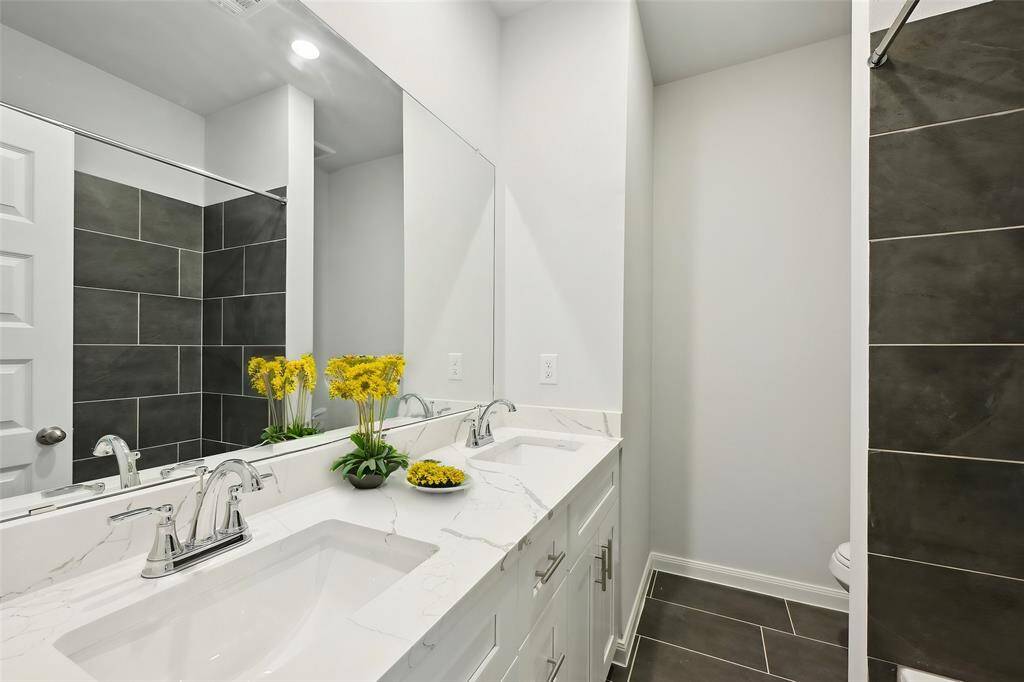 The stylish double-sink vanity provides ample space for morning routines and has plenty of storage.