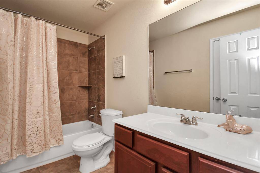 The secondary bathroom is thoughtfully designed with modern fixtures, a tub-shower combo, and ample counter space for added convenience.