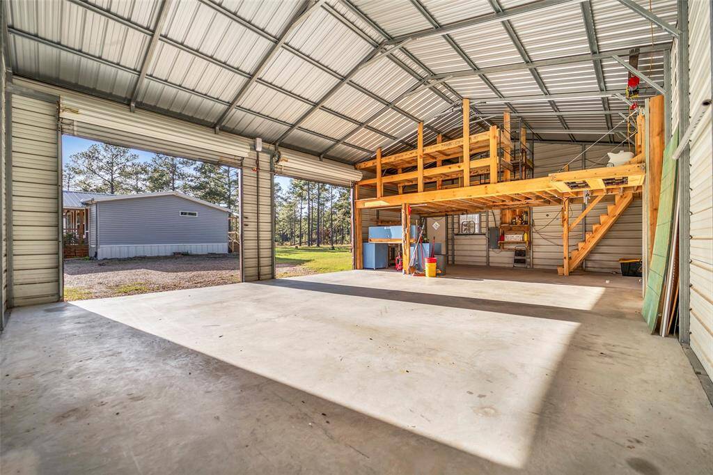 View of the Workshop and 2 car garage and additional storage with a lift for easy access to the storage area (lift is up in this photo)
