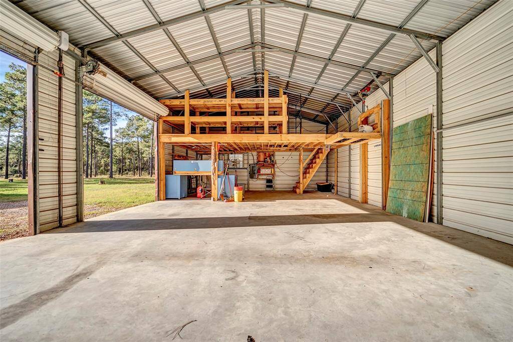 Another angle of the workshop and garage with lift to additional storage