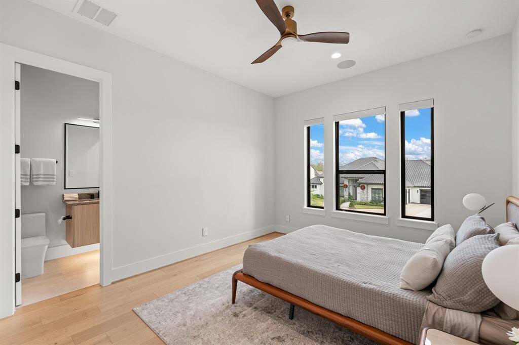 Serene secondary bedroom features fabulous flooring, oversized windows, recessed lighting, and a private en suite bathroom, creating a peaceful and comfortable retreat.