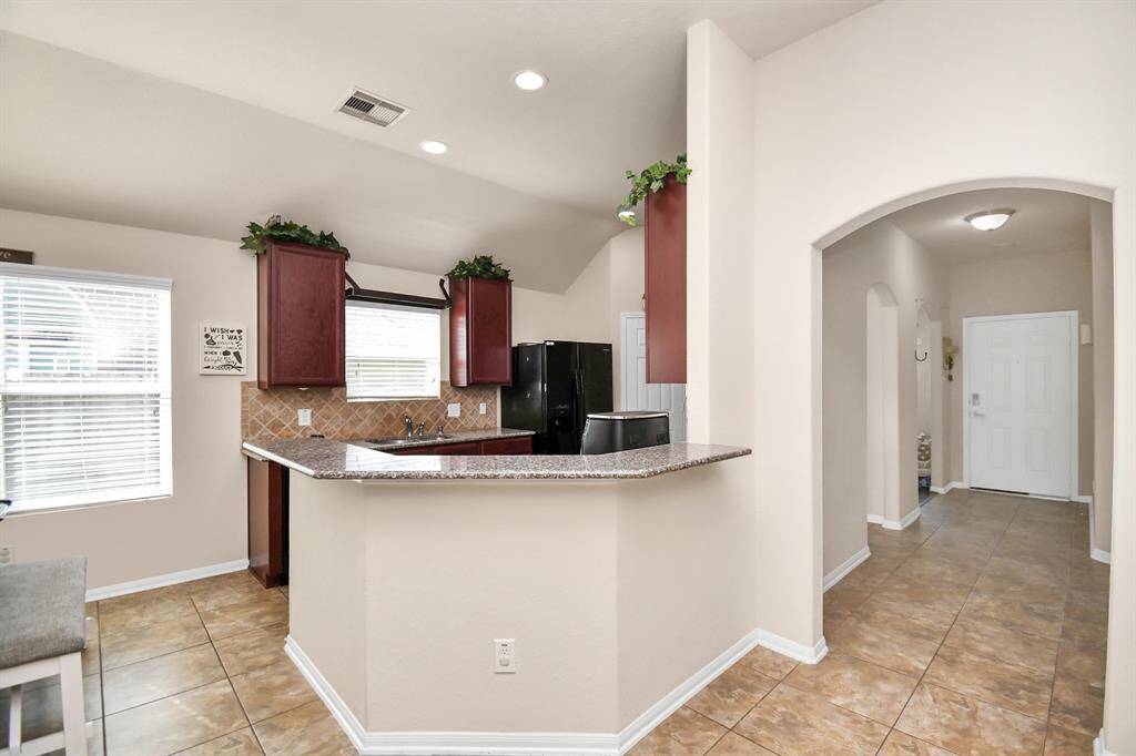 The soaring ceilings add a sense of grandeur, while the rich engineered hardwood and sleek tile flooring flow seamlessly throughout.