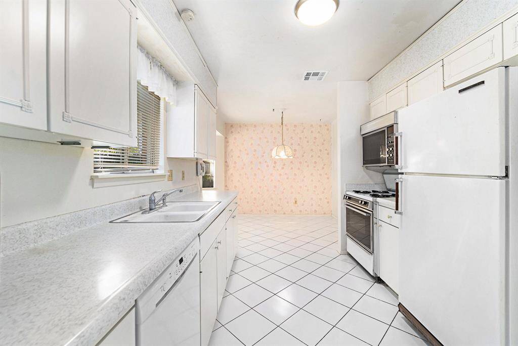 Sunny kitchen has gas range and tile floors
