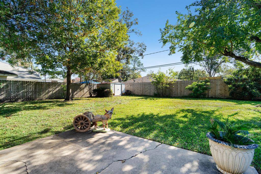 Wonderful patio to view the grassy back yard with shade trees and storage shed