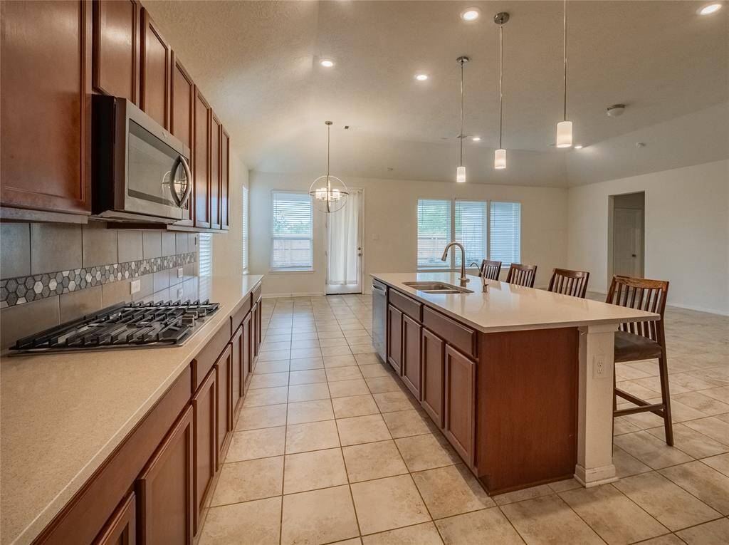 the kitchen has granite counter tops , your island with the sink and breakfast bar