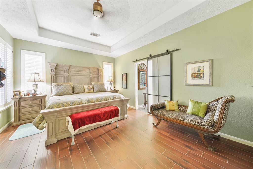 Large primary bedroom with tray ceiling to add to the spaciousness
