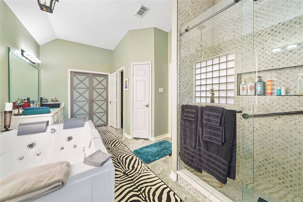Primary bathroom with custom jet tub, walk in closet, and smart toilet.