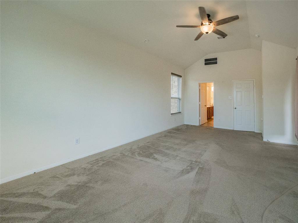 the primary bedroom has a ceiling fan and primary  bath has double doors