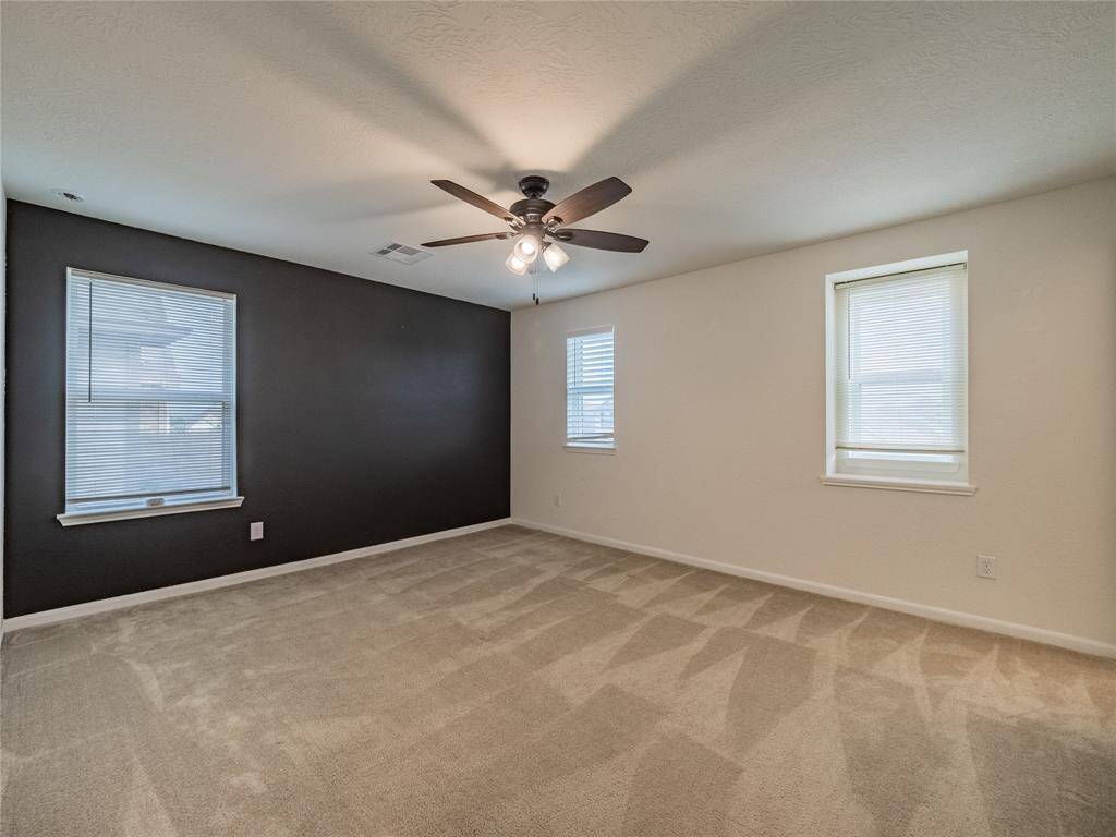 bedroom 4 upstairs with ceiling fan and lots of windows