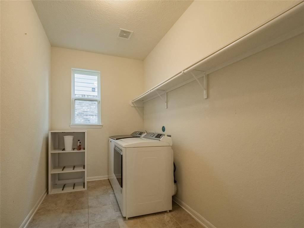 laundry room is on the first floor with a window , racks to hang your laundry on and storage above