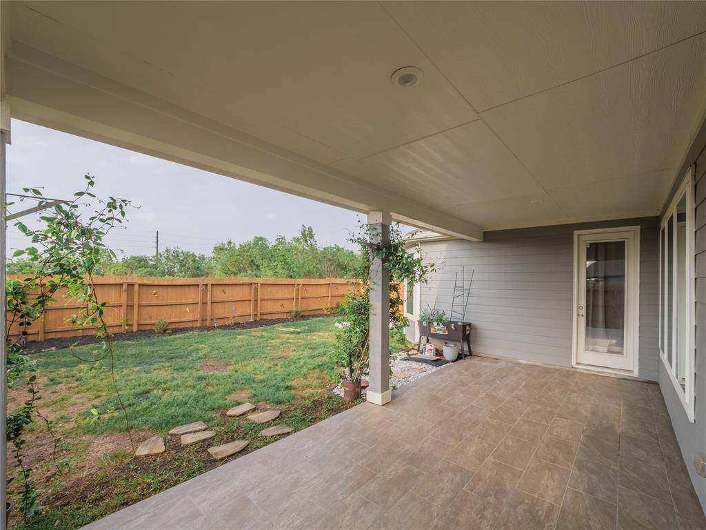 your covered patio with and entrance to the master and kitchen , green space directly behind your home